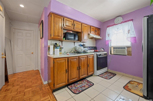 kitchen featuring cooling unit, sink, stainless steel fridge, gas range gas stove, and light tile patterned flooring