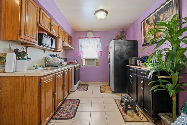 kitchen featuring white gas stove, sink, stainless steel fridge, cooling unit, and light tile patterned flooring