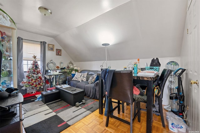 dining space featuring parquet flooring and vaulted ceiling