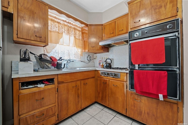 kitchen featuring stainless steel gas stovetop, light tile patterned flooring, sink, and double oven