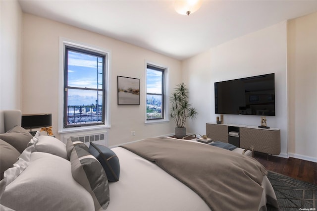 bedroom with dark hardwood / wood-style flooring and radiator