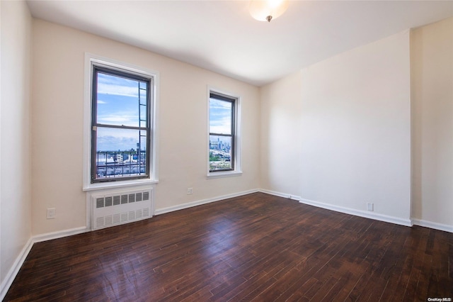 unfurnished room featuring dark hardwood / wood-style floors and radiator