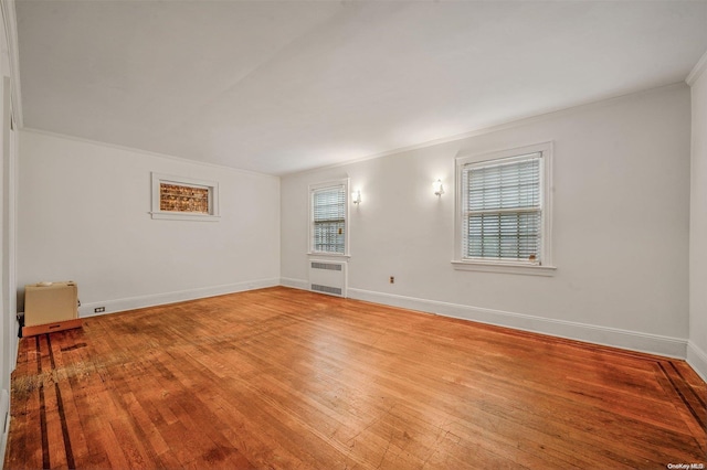 unfurnished room featuring radiator heating unit, light hardwood / wood-style floors, and ornamental molding