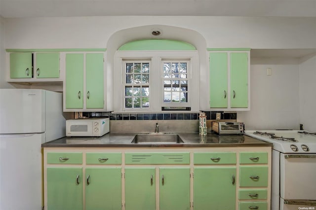 kitchen with white appliances, sink, and green cabinetry