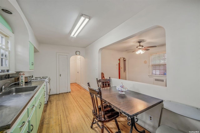 dining room with ceiling fan, sink, and light wood-type flooring