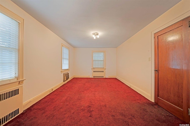 spare room with carpet floors and radiator