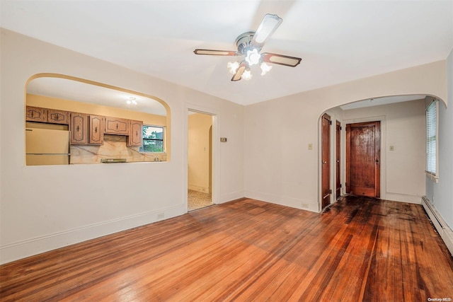 unfurnished living room with dark hardwood / wood-style floors, ceiling fan, and baseboard heating