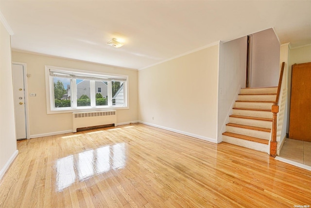 unfurnished living room with radiator heating unit, light hardwood / wood-style flooring, and ornamental molding