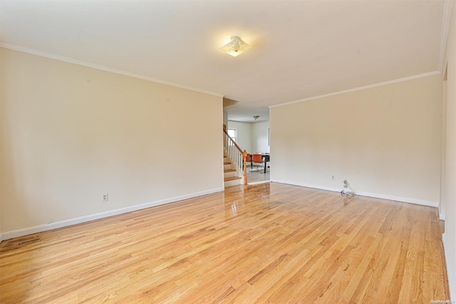 spare room with crown molding and light hardwood / wood-style flooring