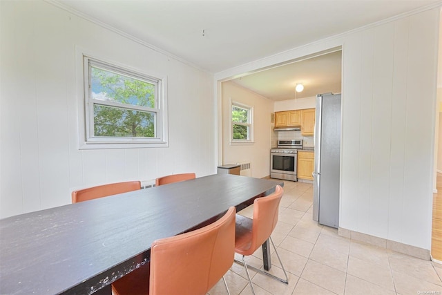 dining area featuring light tile patterned floors and ornamental molding