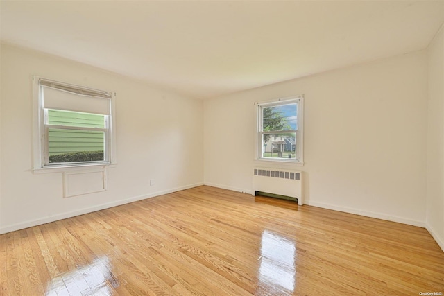 spare room featuring light hardwood / wood-style floors and radiator heating unit