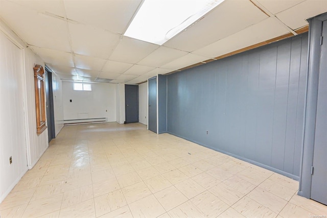 basement with a drop ceiling and a baseboard heating unit