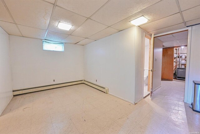 basement with baseboard heating and a drop ceiling