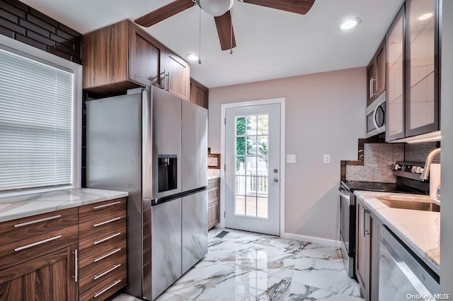 6 George Ave, Hicksville, NY 11801 - kitchen featuring appliances with stainless steel finishes, a ceiling fan, backsplash, light marble finish flooring, and light stone countertops