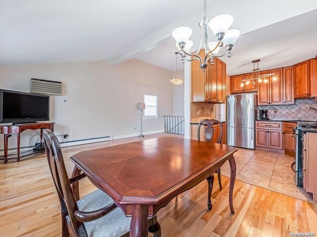 dining space featuring lofted ceiling with beams, light hardwood / wood-style floors, and an inviting chandelier