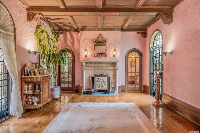 sitting room featuring beam ceiling, a wealth of natural light, hardwood / wood-style floors, and wood ceiling