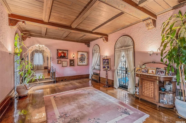 sitting room featuring beam ceiling, hardwood / wood-style floors, and wooden ceiling