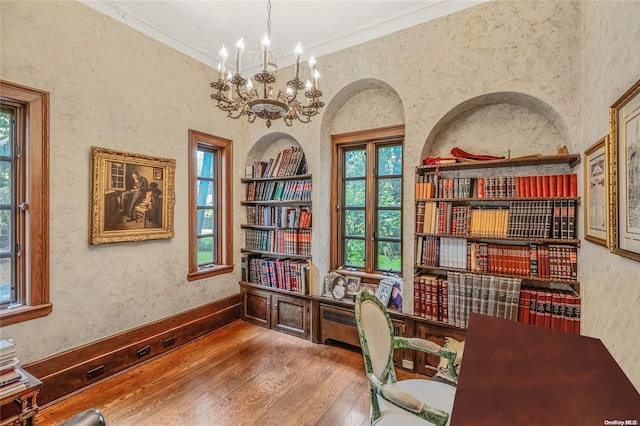 office with crown molding, plenty of natural light, an inviting chandelier, and hardwood / wood-style flooring