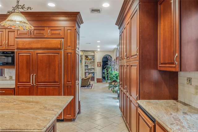 kitchen with tasteful backsplash, light stone countertops, black appliances, and hanging light fixtures