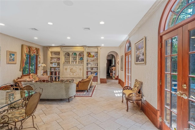 living room featuring french doors, built in features, and ornamental molding