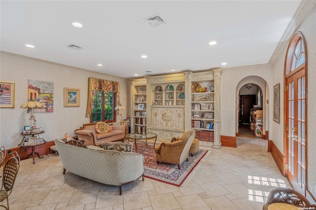 interior space with built in shelves, crown molding, and french doors