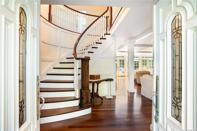 entrance foyer with dark hardwood / wood-style flooring, ornate columns, and ornamental molding