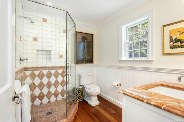 bathroom with vanity, crown molding, hardwood / wood-style floors, toilet, and a shower with shower door