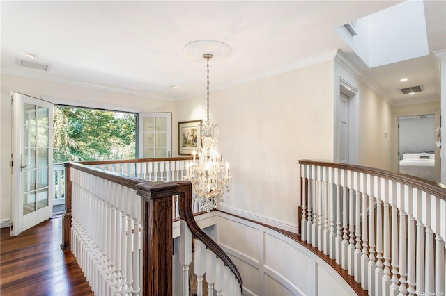 hallway featuring dark hardwood / wood-style flooring, an inviting chandelier, and crown molding