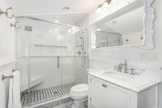 bathroom featuring vanity, toilet, and a shower with shower door