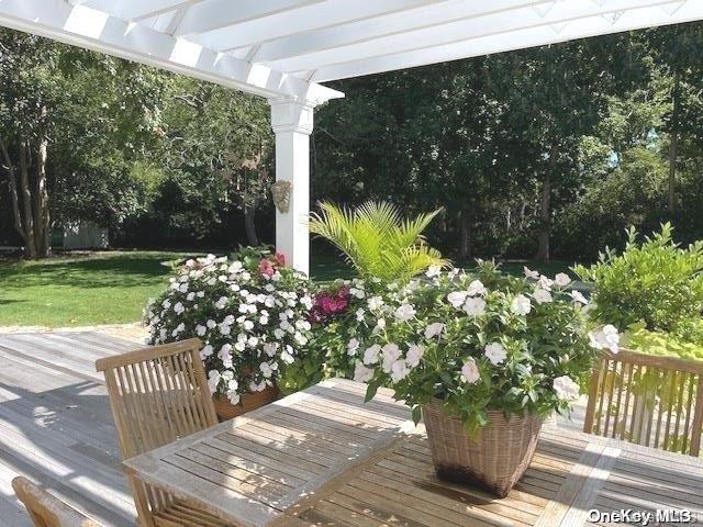 wooden deck with a yard and a pergola