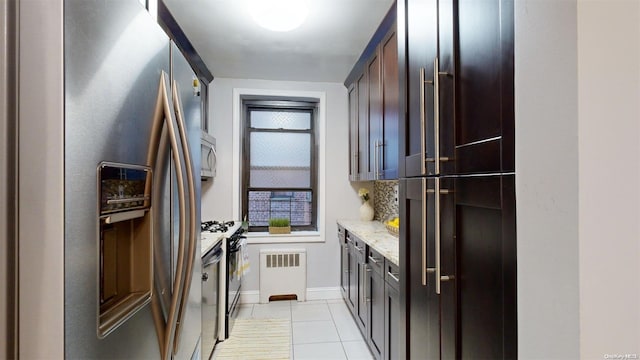 kitchen featuring light stone countertops, light tile patterned floors, stainless steel appliances, and dark brown cabinets