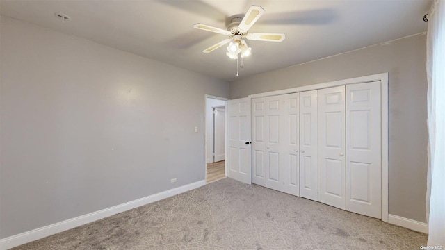 unfurnished bedroom with light carpet, a closet, and ceiling fan