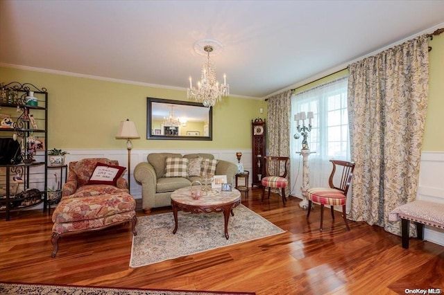 living room featuring hardwood / wood-style floors, ornamental molding, and an inviting chandelier