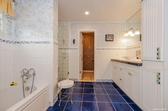 bathroom featuring tile patterned flooring, vanity, tile walls, and shower with separate bathtub