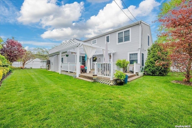 rear view of property featuring a lawn, a pergola, and a wooden deck