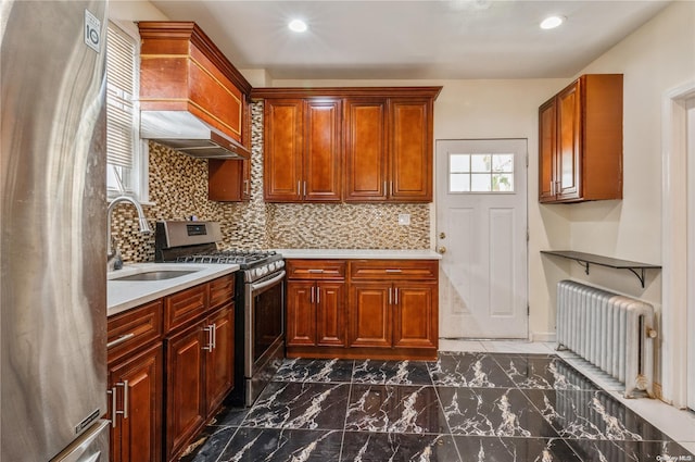 kitchen with radiator, sink, wall chimney exhaust hood, stainless steel appliances, and decorative backsplash