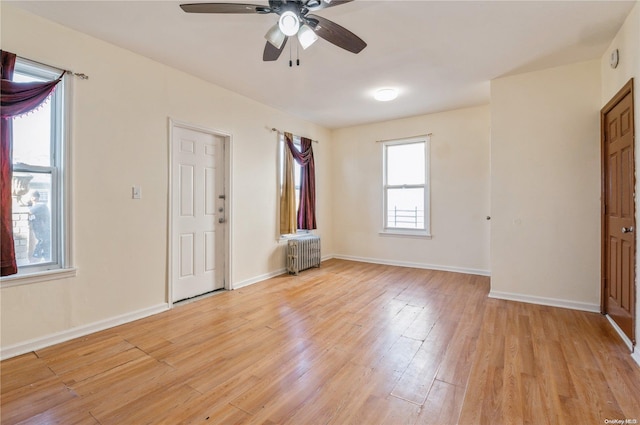 interior space with ceiling fan, light hardwood / wood-style floors, and radiator heating unit