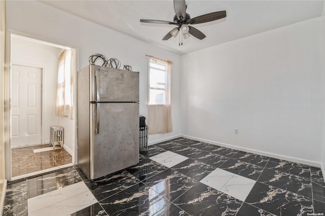 interior space featuring stainless steel fridge, radiator heating unit, and ceiling fan