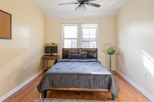 bedroom with ceiling fan, light hardwood / wood-style flooring, and lofted ceiling