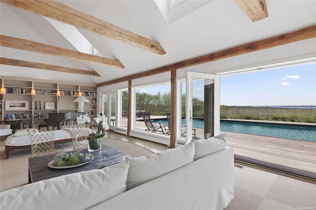 living room with lofted ceiling with beams and a water view