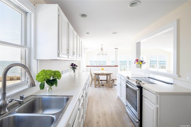 4235 Camp Mineola Rd, Mattituck, NY 11952 - kitchen featuring electric stove, a sink, a chandelier, white cabinets, and light wood finished floors