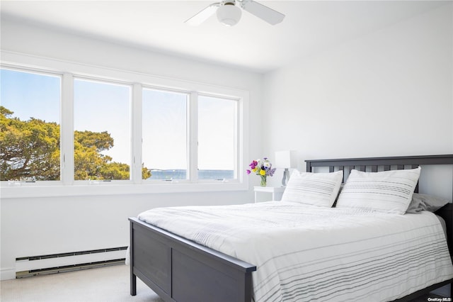 bedroom featuring carpet flooring, ceiling fan, and a baseboard heating unit