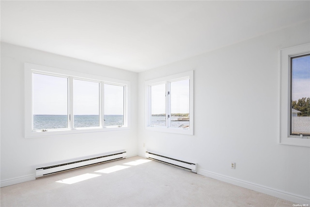 carpeted spare room with a water view, plenty of natural light, and baseboard heating