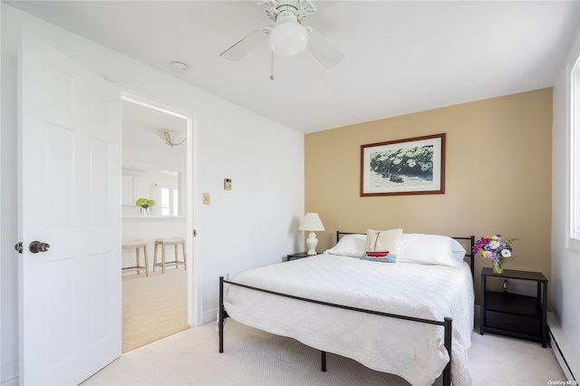 carpeted bedroom with ceiling fan and a baseboard radiator