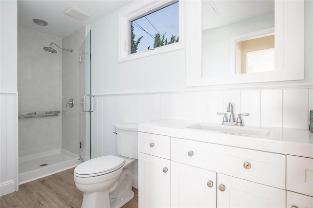 4235 Camp Mineola Rd, Mattituck, NY 11952 - bathroom featuring a stall shower, vanity, toilet, a wainscoted wall, and wood finished floors