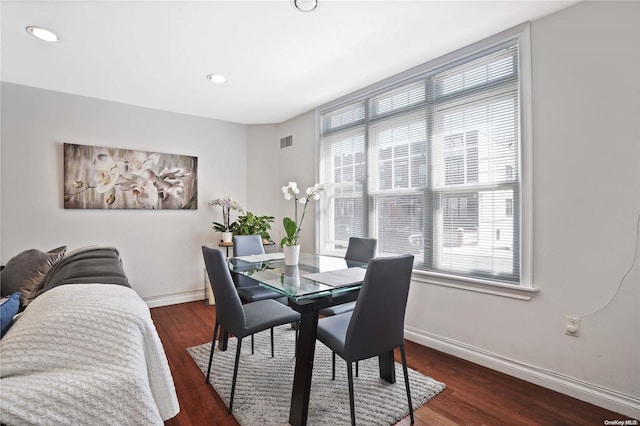 dining area featuring dark wood-type flooring and a healthy amount of sunlight