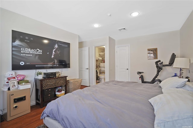 bedroom with dark hardwood / wood-style flooring and ensuite bath