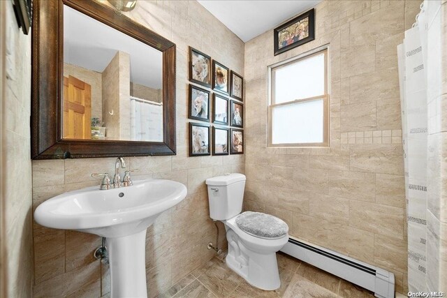 bathroom featuring walk in shower, toilet, tile walls, and a baseboard heating unit