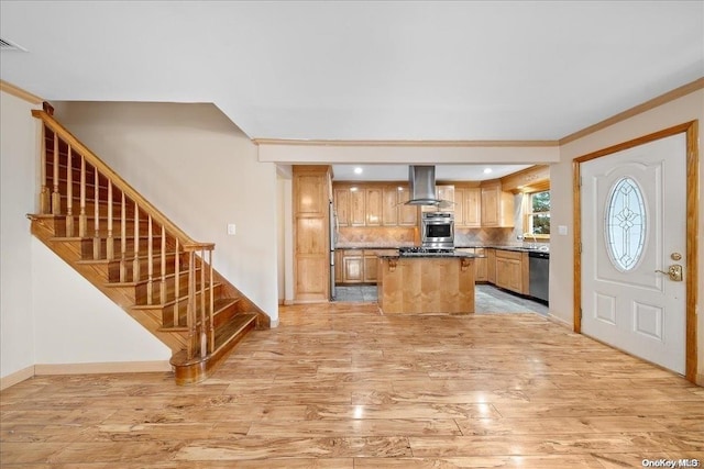 kitchen featuring appliances with stainless steel finishes, a center island, tasteful backsplash, and light hardwood / wood-style flooring