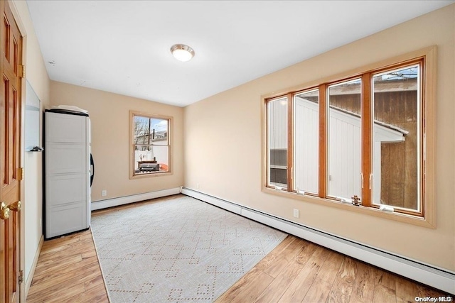 unfurnished room with light wood-type flooring and baseboard heating